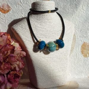 Collana in caucciù nero con componenti dorati effetto graffiato e perle in ceramica